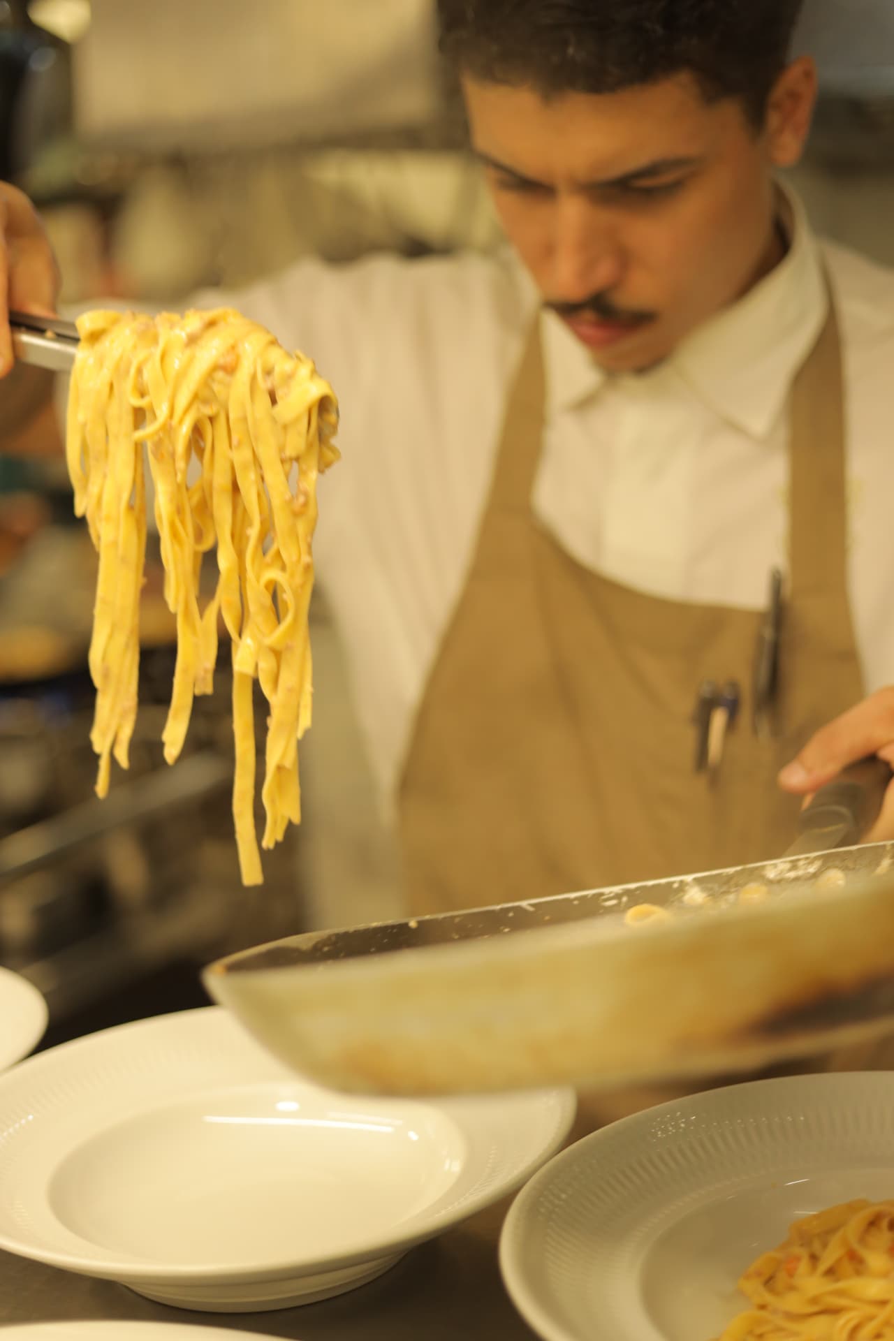 Chef empratando massa fresca na cozinha durante o jantar